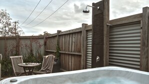 Ein Whirlpool in einem Garten mit Holzpferd, einem Tisch und Stühlen.