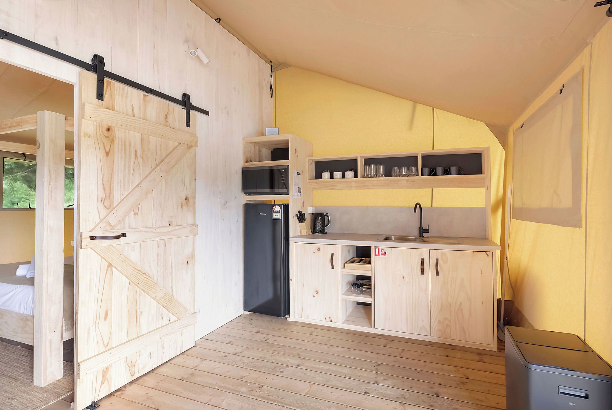 A compact kitchen with wooden cabinets, a built-in microwave, and a sink.