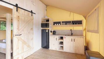 Een compacte keuken met houten kastjes, een ingebouwde magnetron en een spoelbak.