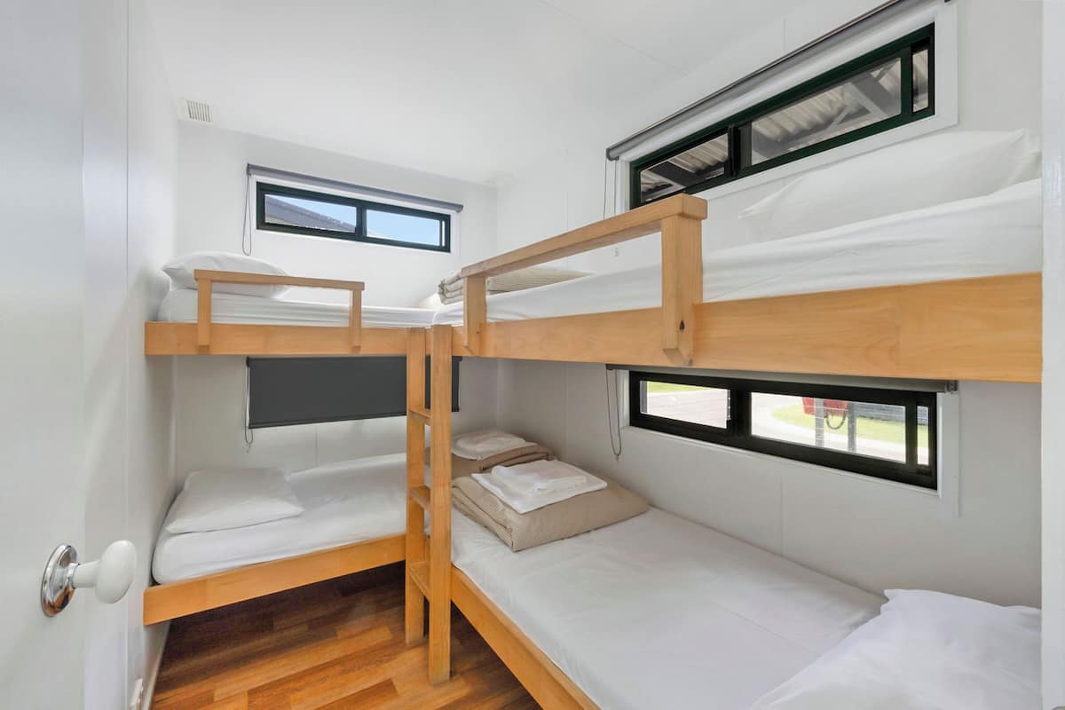 A compact, bunk-style room with two beds and a small window.