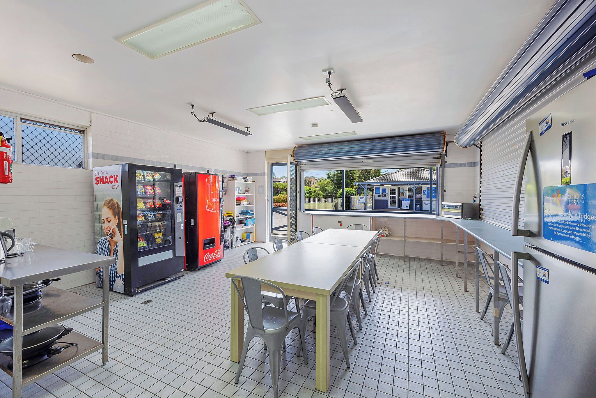 A clean, well-lit restaurant with a long counter, seating area, and vending machines.