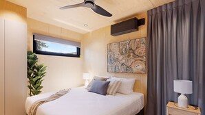 A modern bedroom with a large bed, a ceiling fan, a mounted TV, a painting, and a bedside table with a lamp. - Reflections Hawks Nest - Holiday Park (Hawks Nest)