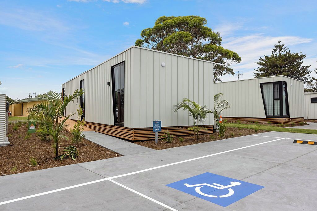 A modern building with a wheelchair-accessible parking space marked on the pavement.