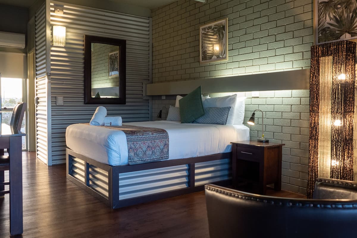 Un dormitorio moderno con una cama grande, un escritorio y una silla.