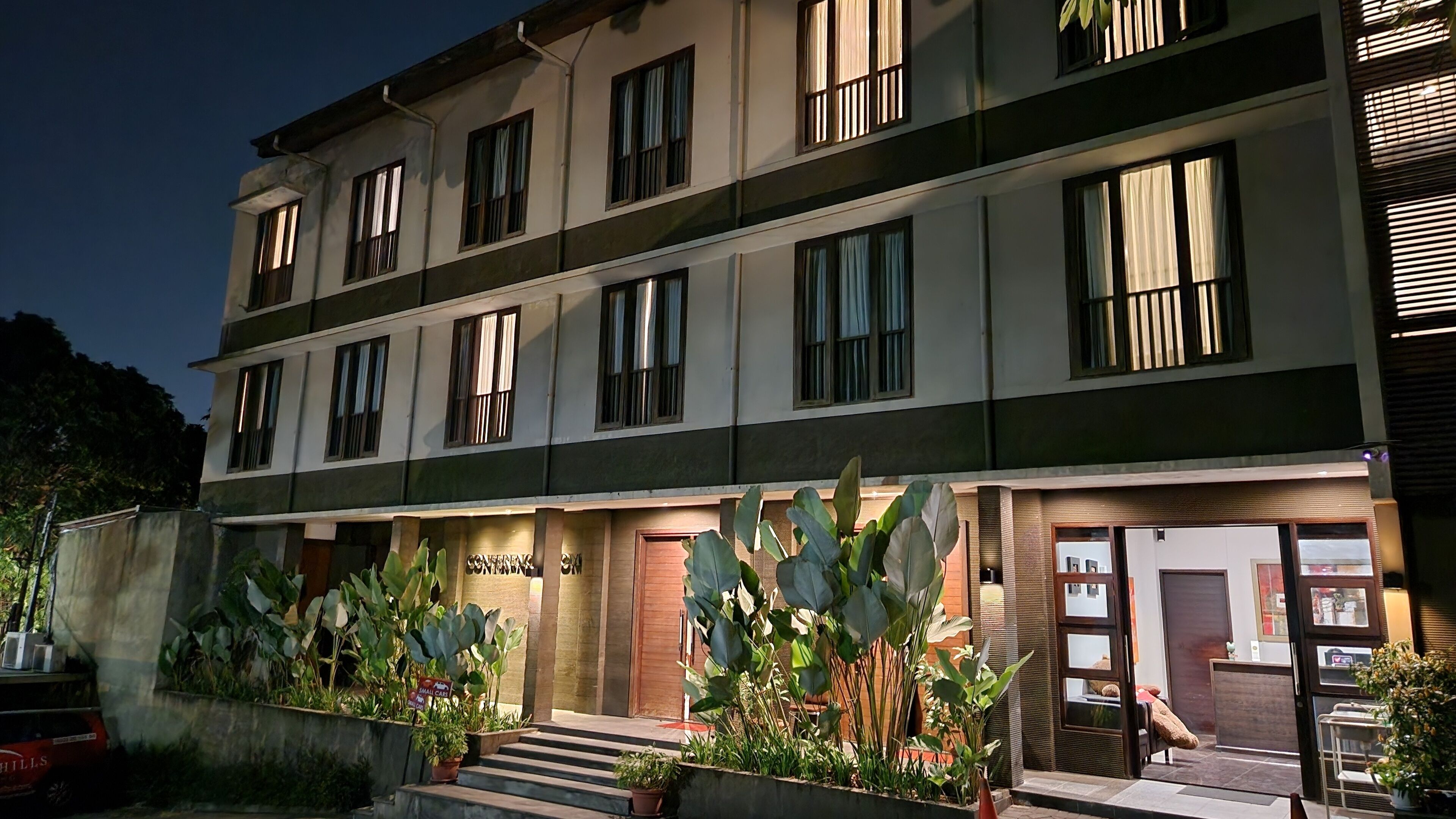 A multi-story hotel with a modern facade, large windows, and a well-lit entrance.