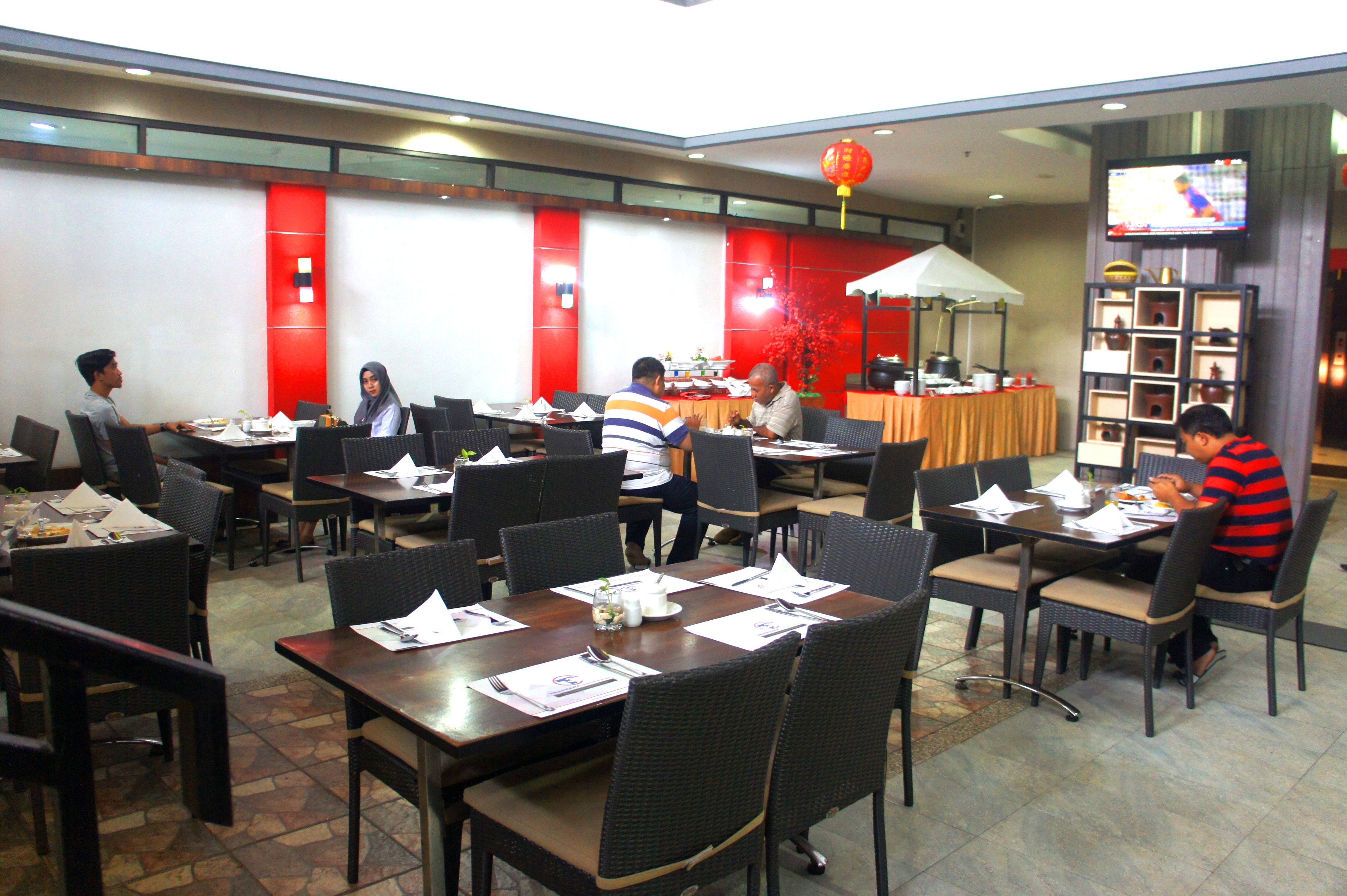 A restaurant with multiple tables and chairs, some with menus and condiments.