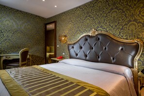 A hotel room with a large bed, a desk, and a chair. - Hotel Ca Marinella (Venice)