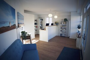 Una cocina moderna con una isla central, suelo de madera e iluminación colgante.