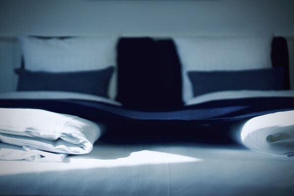 A bed with white linens and a dark headboard. - Plesners Badehotel (Skagen)