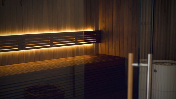 Moderni sauna, jossa on puupanelointi ja penkki.