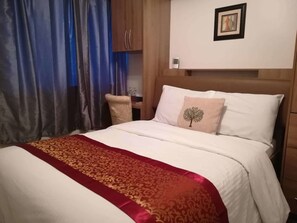 Una habitación de hotel con una cama, un escritorio y una silla.