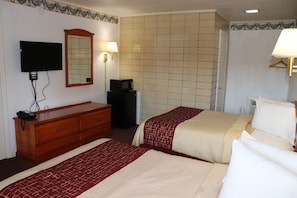 A hotel room with two beds, a TV, a mirror, a dresser, and a lamp. - Bassett Motel (Williamsburg)