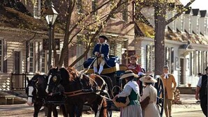 A historical reenactment scene with a horse-drawn carriage and period costumes. - Bassett Motel (Williamsburg)
