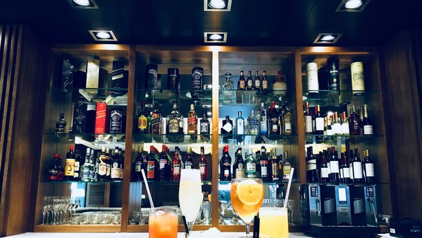 A bar area with multiple shelves of liquor bottles and glasses. - Hotel Metropolitano Supara (Buenos Aires)