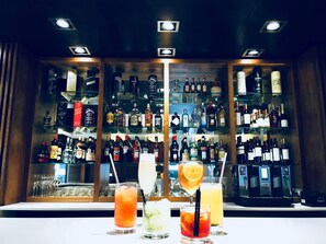A bar area with multiple shelves of liquor bottles and glasses. - Hotel Metropolitano Supara (Buenos Aires)