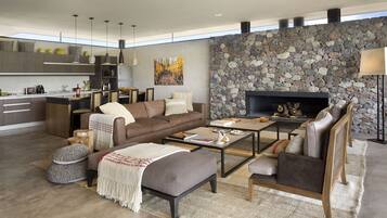 Un espacio habitable moderno con cocina, comedor y zona de estar, que cuenta con una pared de piedra y chimenea.