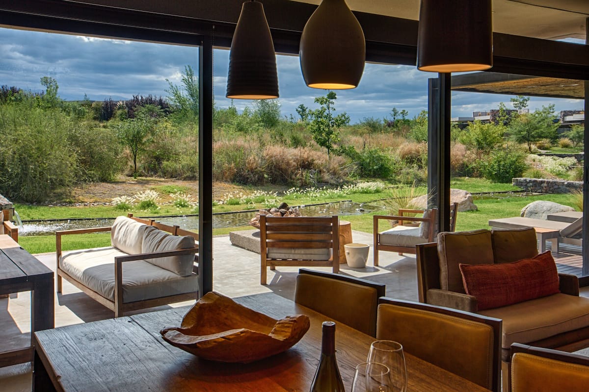 A spacious outdoor seating area with wooden furniture and a view of a natural landscape.