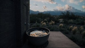 Un jacuzzi grande al aire libre junto a un edificio con vista a las montañas.