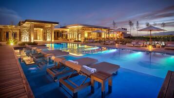 Alberca al aire libre, sombrillas en la alberca y camastros