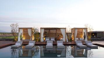 Alberca al aire libre, sombrillas en la alberca y camastros