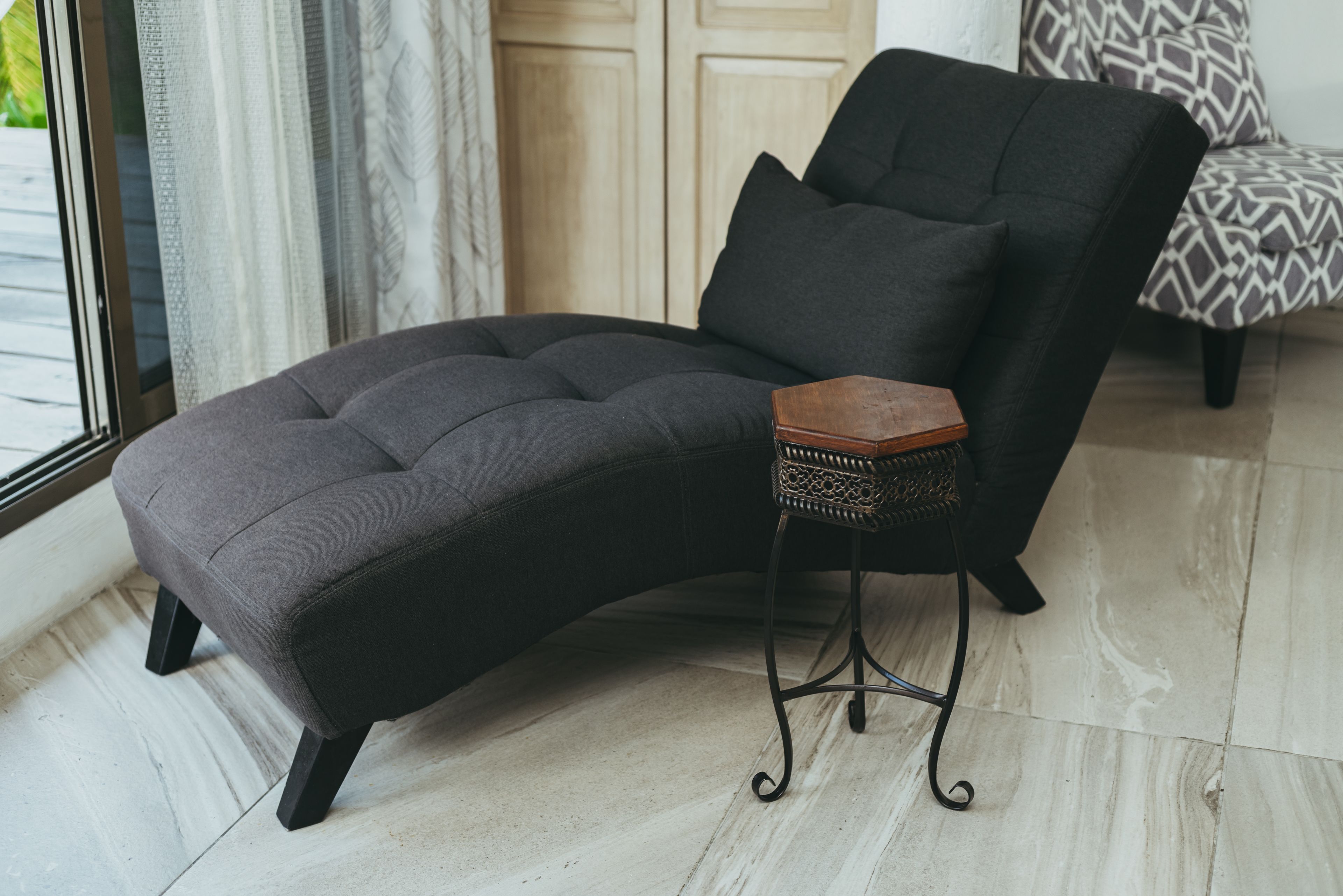 A corner sofa with a matching ottoman and a small side table.