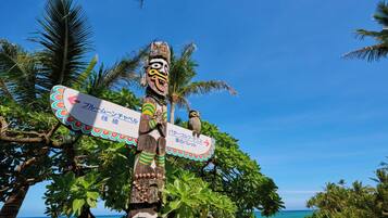 A wooden totem with a carved face and a signboard.