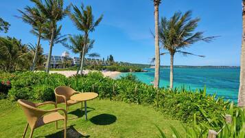A tropical resort with a pool, palm trees, and a view of the ocean.