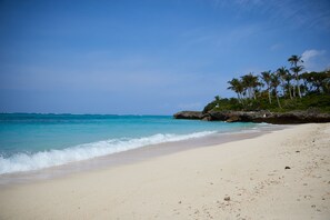 On the beach, white sand, sun-loungers, beach umbrellas