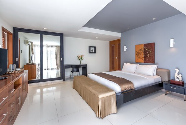 A modern hotel room with a large bed, a desk, and a wardrobe. - Hening Jimbaran (Jimbaran)
