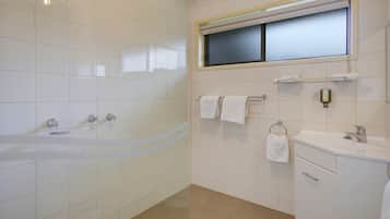 Un baño con bañera, lavamanos y ventana.