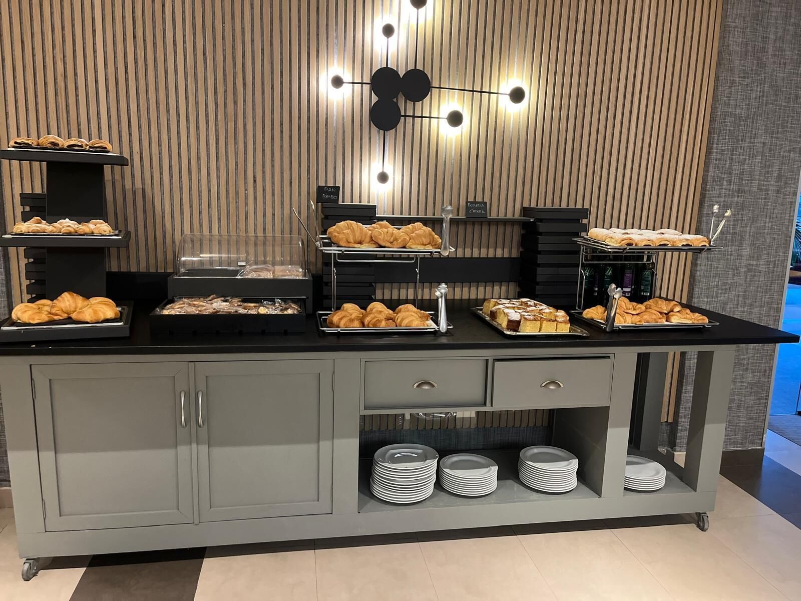 A buffet setup with various pastries and a coffee station.