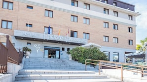 A hotel with a modern design, featuring a prominent entrance with steps leading up to the main door. - Hotel Hidalgo (Esquivias)