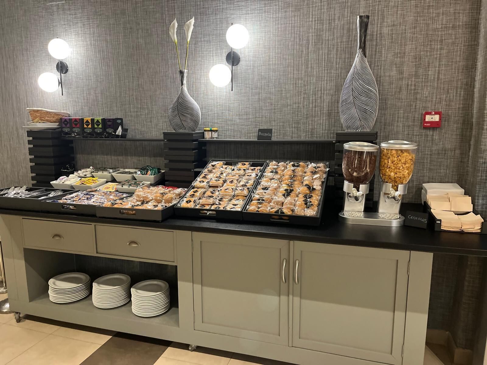 A buffet setup with various food items, a coffee station, and a section for condiments.