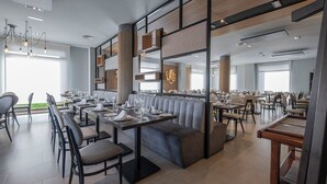 A modern restaurant with high tables, cushioned seating, and a bright interior. - Hotel Hidalgo (Esquivias)