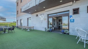 A hotel with a signboard, outdoor seating area, and a clear view of the entrance. - Hotel Hidalgo (Esquivias)