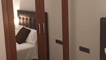 Un dormitorio con un armario grande, una cama y una mesita de noche.