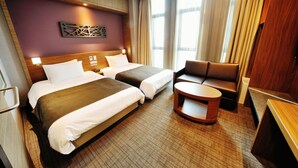 A hotel room with two beds, a sofa, a small table, and a decorative wall piece. - Dormy Inn Premium Seoul Garosugil (Seoul)