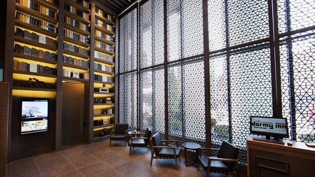 A library with bookshelves, a television, and seating areas. - Dormy Inn Premium Seoul Garosugil (Seoul)
