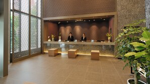A reception area with a modern design, featuring a reception desk, seating area, and decorative plants. - Dormy Inn Premium Seoul Garosugil (Seoul)