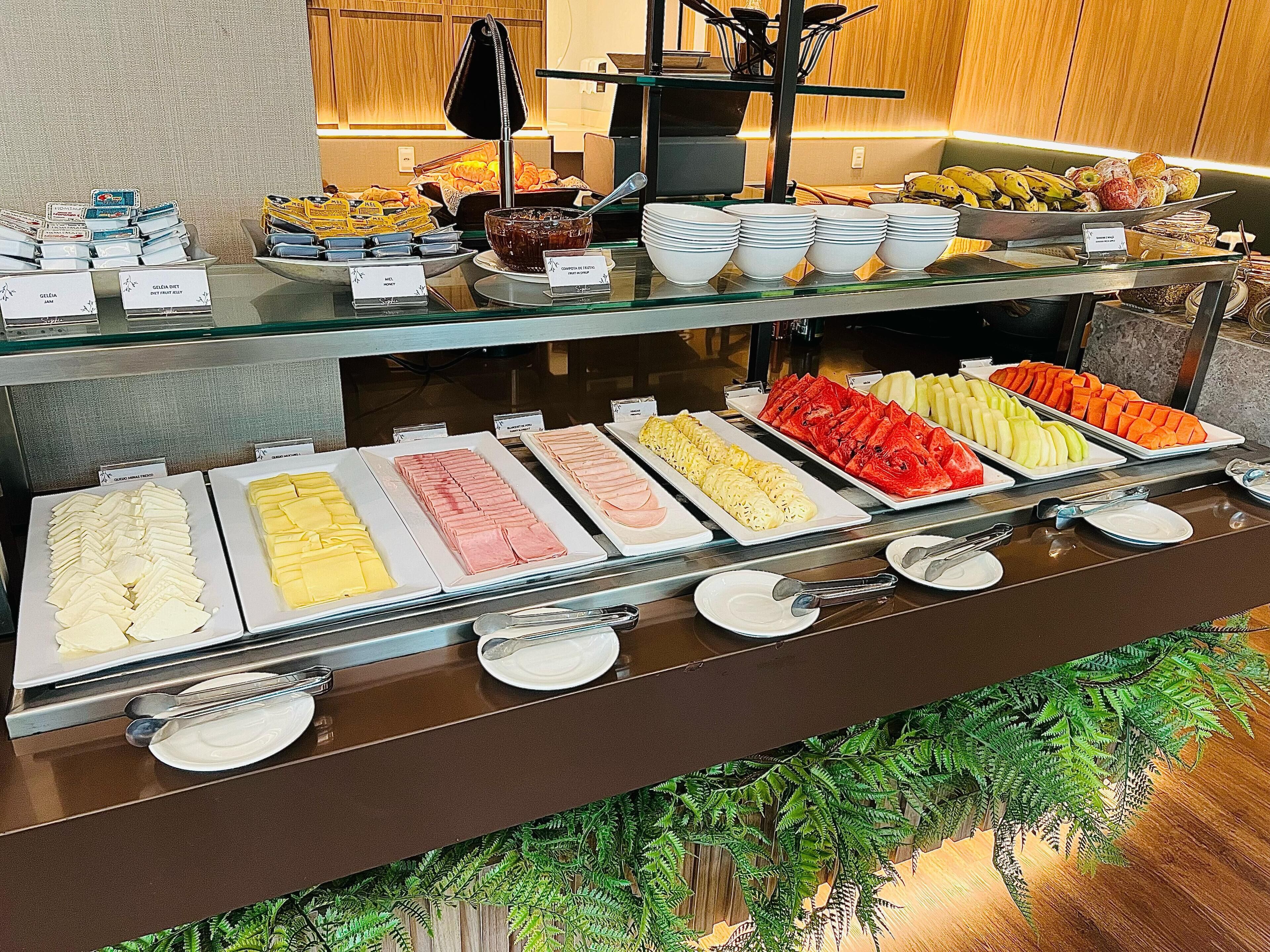 Um buffet com diversos alimentos e utensílios.