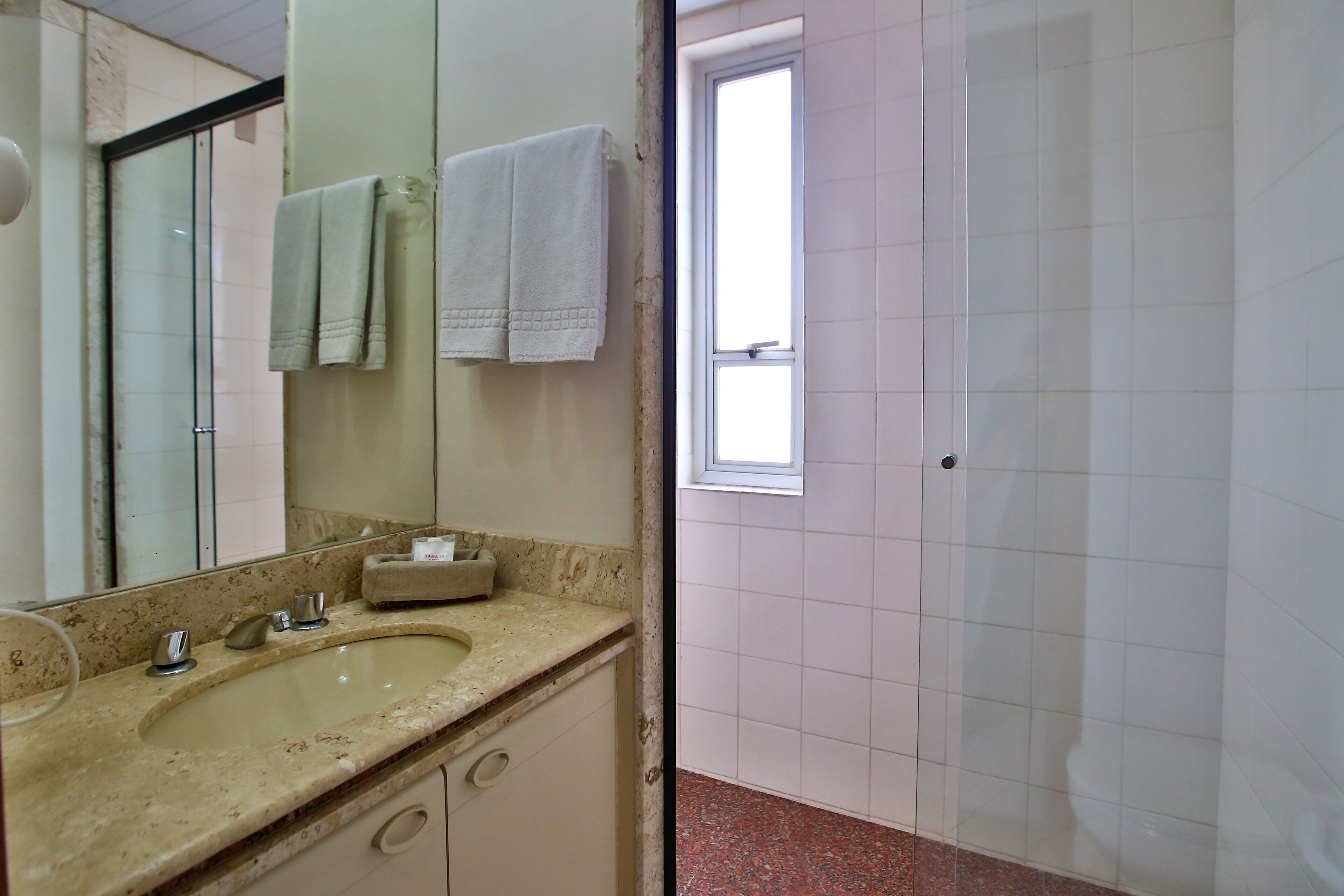 Une salle de bain avec un lavabo, un miroir et des serviettes.