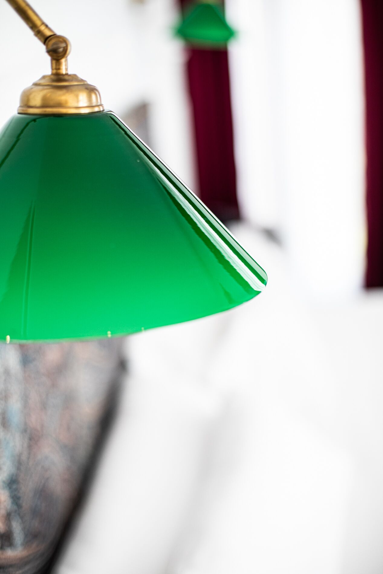 A close-up of a green glass lamp with a brass base.