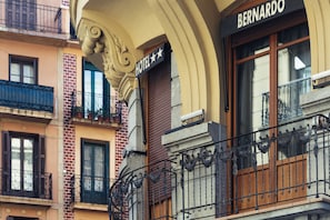 Fachada de hotel con un cartel que dice "BERNARDO HOTEL", destacando barandillas de hierro ornamentadas y una fachada de ladrillo.