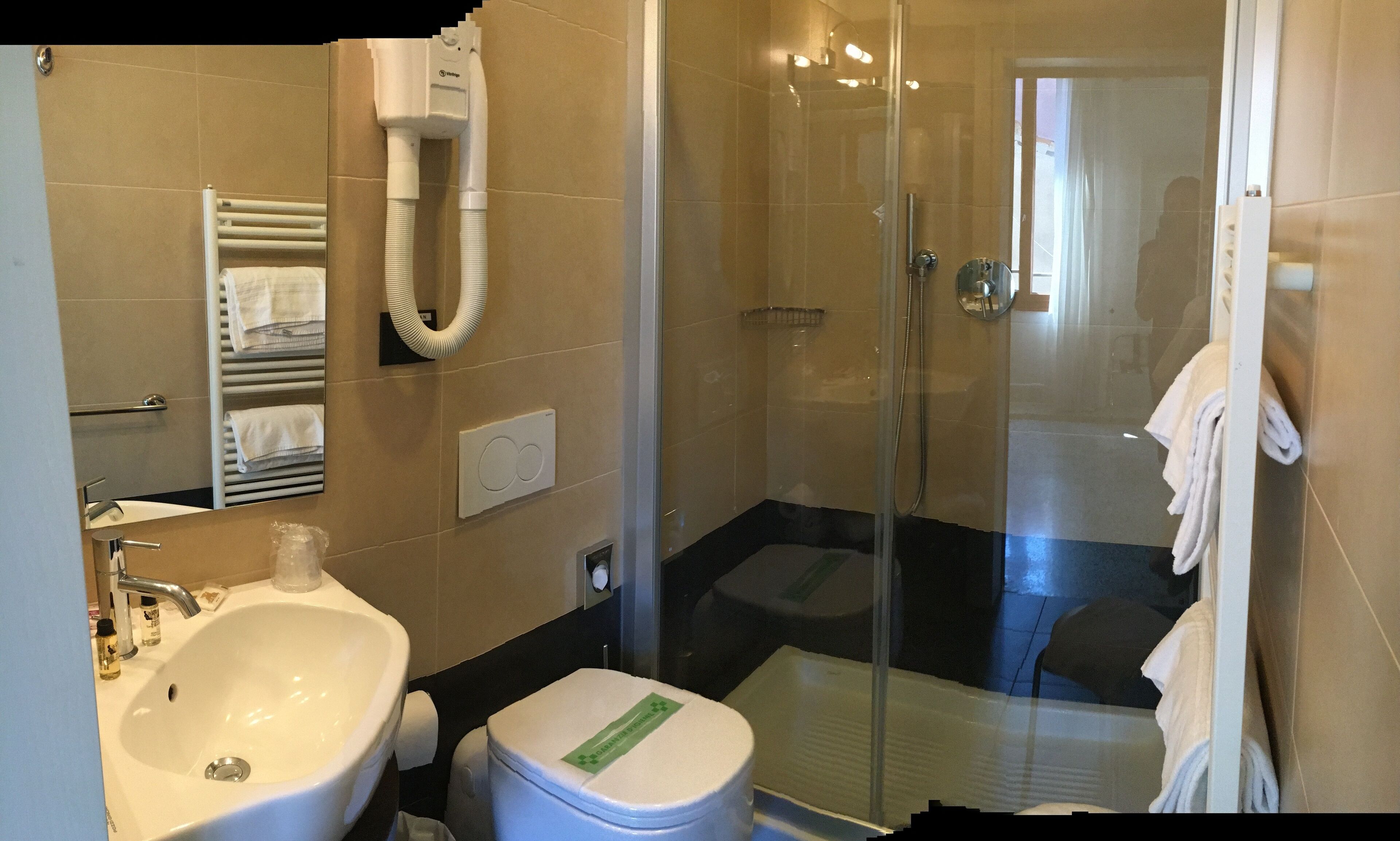 A modern bathroom with a sink, toilet, and glass shower enclosure.