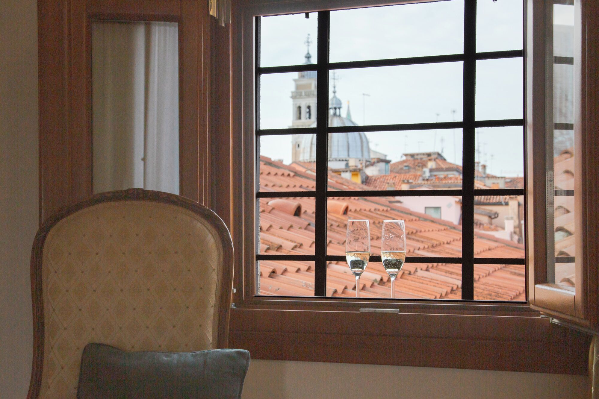 A room with a view of a cityscape through a window with a grid pattern.