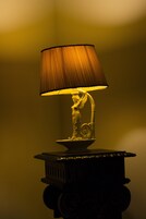 Eine Tischlampe mit einem gefalteten Lampenschirm und einer verzierten Basis.