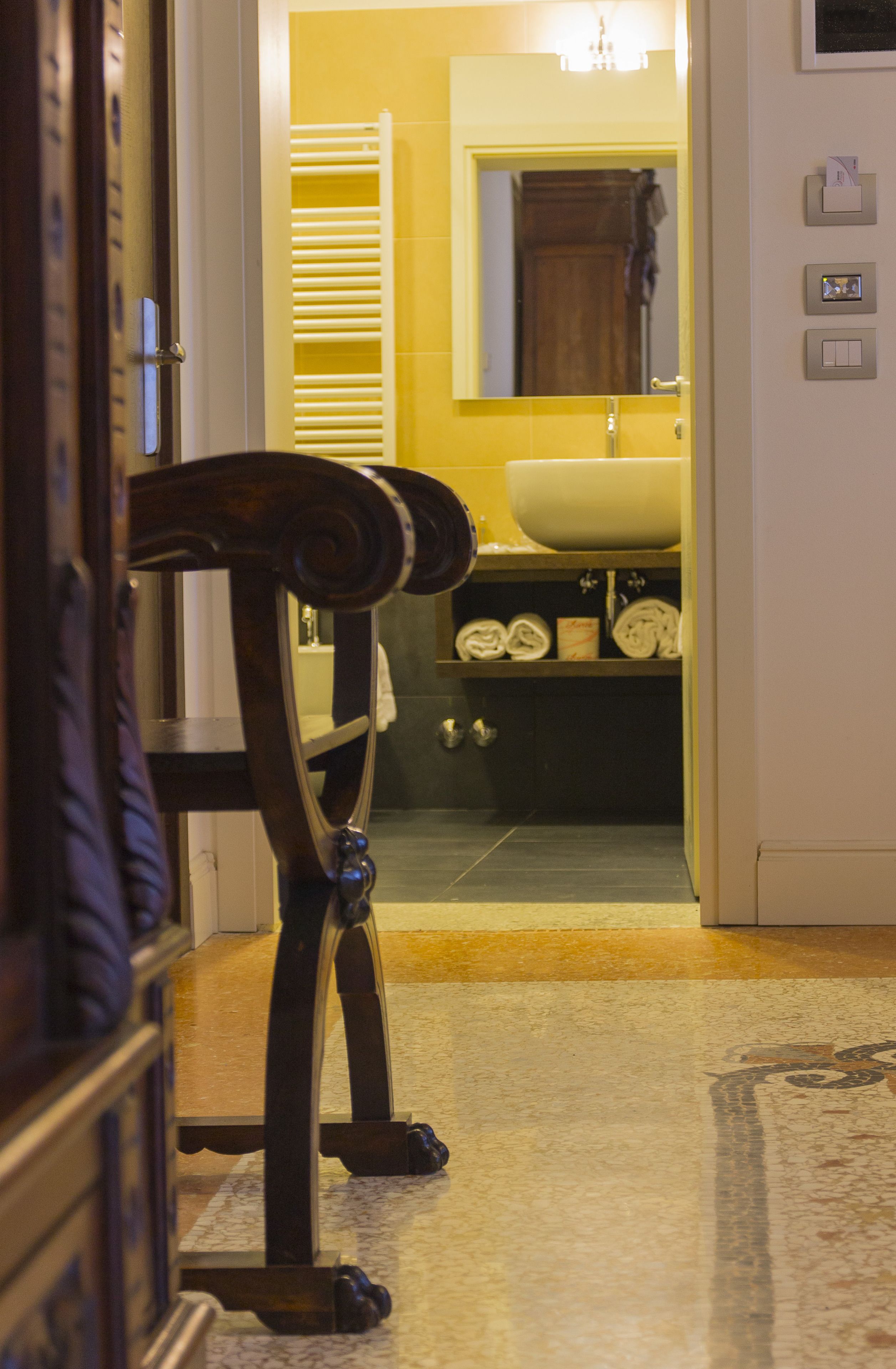 Un baño con una pared amarilla, un lavamanos y un espejo.
