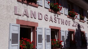 A building with the sign "LANDGASTHOF LÖREN" and multiple windows with shutters and flower boxes. - Hotel & Gasthaus Löwen (Waldkirch)