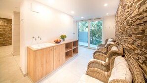 A modern bathroom with a wooden vanity, a large sink, and wicker seating by the window. - Hotel & Gasthaus Löwen (Waldkirch)