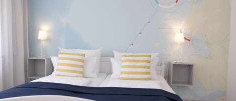Een slaapkamer met een bed, twee nachtkastjes en een wereldkaart aan de muur.